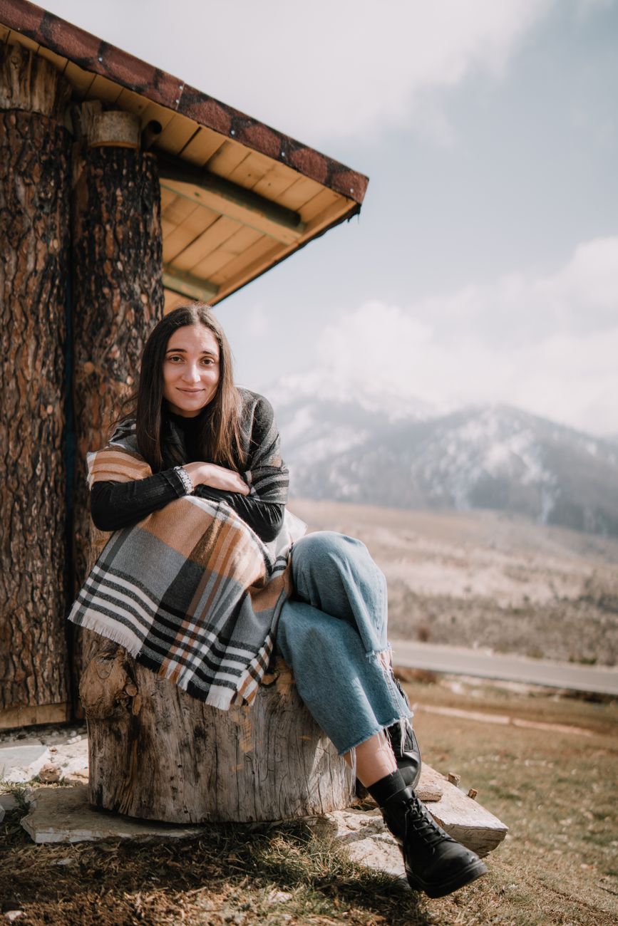 Travel writer reviewing notebooks in an authentic mountain cottage